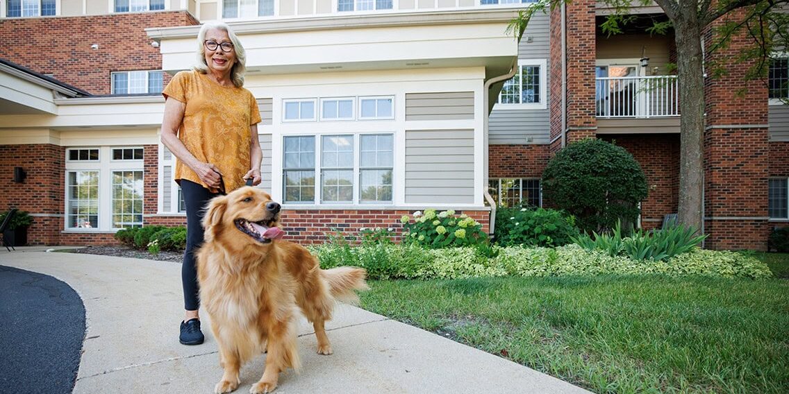 A woman walking her dog in front of the building