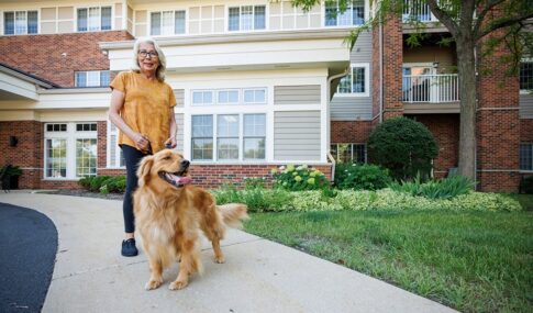 A woman walking her dog in front of the building