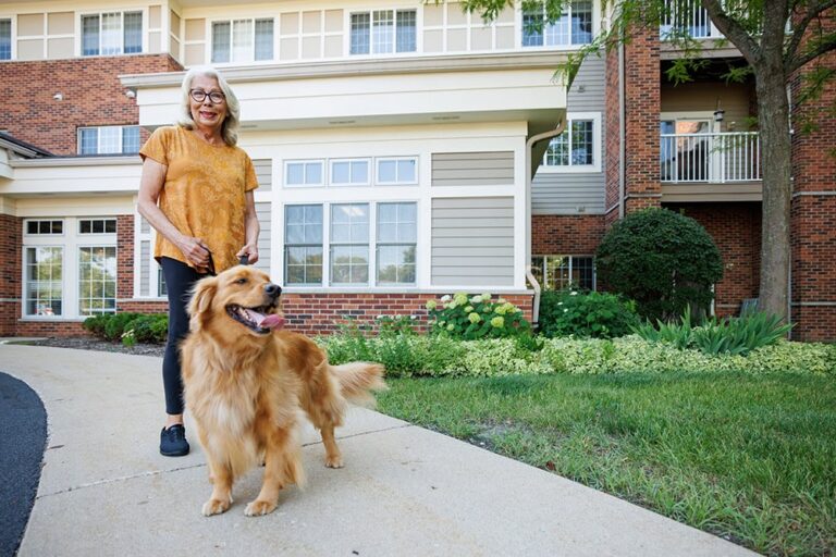 A woman walking her dog in front of the building