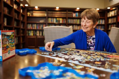 A woman working on a puzzle in the library