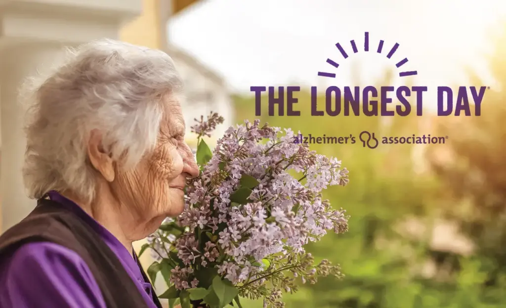Alzheimers patient smelling lilacs with The Longest Day logo