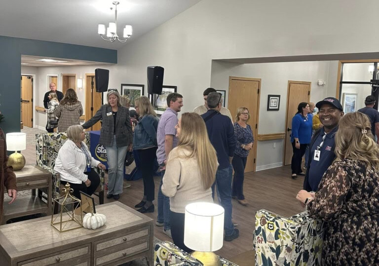 Overview of open house group in warm gathering area